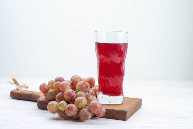 新鲜正面图白色桌上的酸鲜葡萄汁水果新鲜醇厚的果汁饮料瓶子酸的葡萄