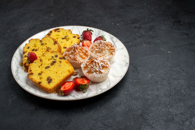 生的正面图美味的蛋糕片 新鲜的红色草莓和饼干放在灰色表面蛋糕烘焙饼干糖甜饼饼干切片烘焙盘子