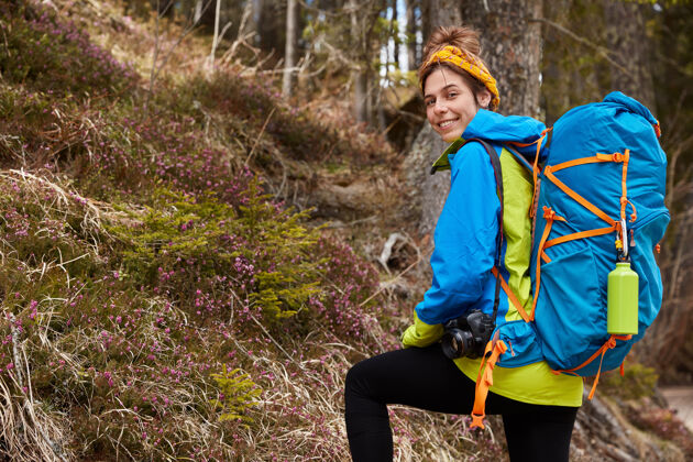 森林快乐女露营者携带背包 专业相机风景自然头巾