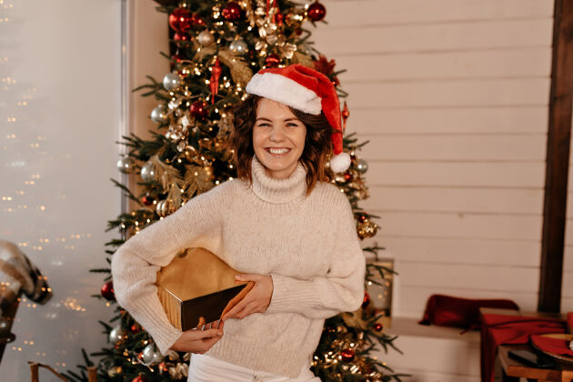 节日带着圣诞礼物微笑的女人圣诞树圣诞盒子