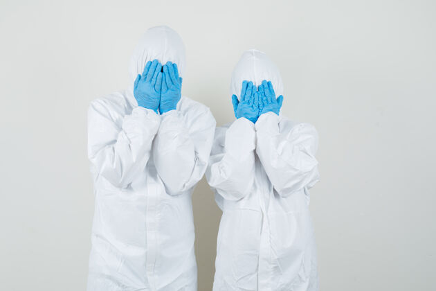 防护两个医生穿着防护服 戴着手套用手捂住脸 看上去很害怕医疗瓶子肖像