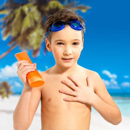 日光浴小学生在晒黑的身体上涂防晒霜身体海滩放