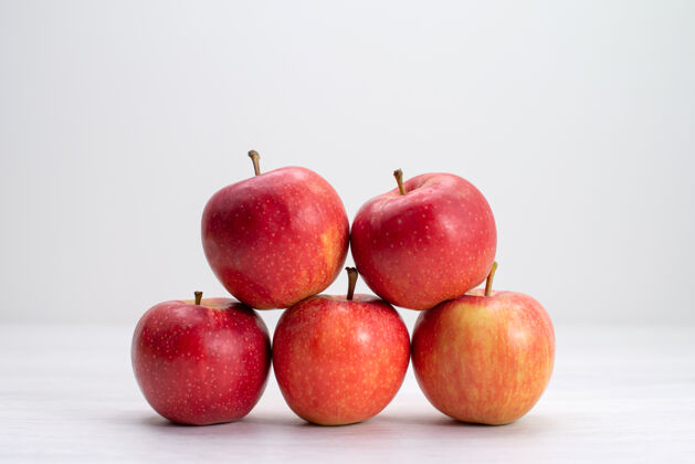 苹果正面图红色的新鲜苹果衬在白色的书桌上水果新鲜醇厚成熟的树株素食生的维生素