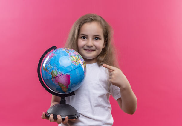 地球仪微笑着的小女孩穿着白色t恤拿着地球仪 背景是孤立的粉色学校女孩抱着