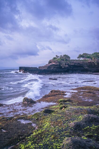 海滩阴天有悬崖的海边的垂直镜头自然海湾风景