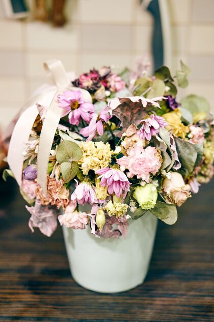 死木桌上盛开枯萎花朵的花瓶特写镜头叶花瓣浪漫