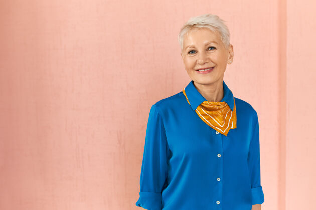脸时尚自信成熟的白人女性的横向肖像 在空白的粉色墙壁上摆着精灵般的金发老年老年女士
