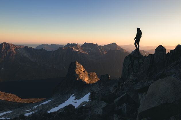 胜利一个人站在山顶上的剪影 在早晨美丽多彩的天空下顶峰登山户外