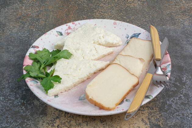 食品美味的奶酪片和餐具一起放在盘子里早餐奶酪美味