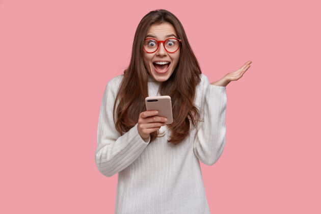 青少年快乐美丽的女士 有着迷人的外表 举手 有着喜出望外的表情 如收到含有爱情告白的短信 在网上聊天的短信面部阅读技术