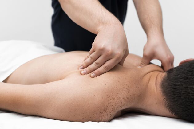 理疗理疗师按摩男性患者的背部男子理疗创伤