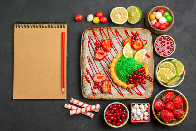 盘子俯瞰美味的奶油蛋糕和水果深色背景饼干甜点甜的颜色餐点钱食物