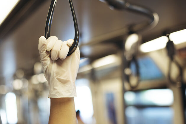 公共手戴乳胶手套 同时手持火车扶手 防止冠状病毒污染设计空间一次性卫生处理