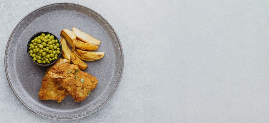 复制盘子上有豌豆的炸鱼薯条俯视图和复印空间餐空间英国菜