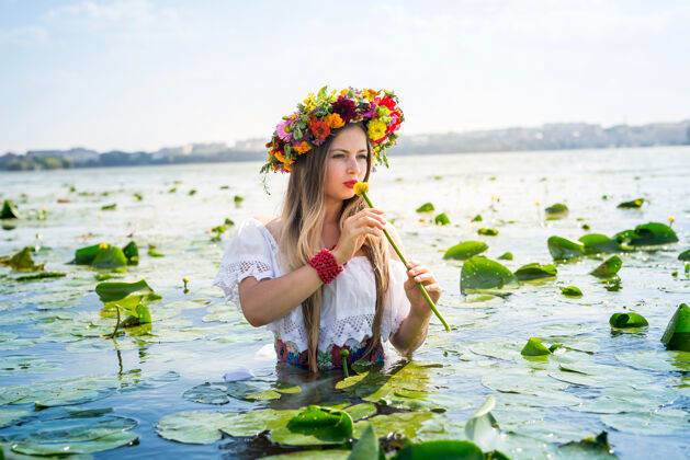 项链美丽的女孩与睡莲站在水中金发肖像乌克兰