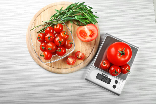 烹饪木桌上的西红柿和数字厨房秤目录数字电路板