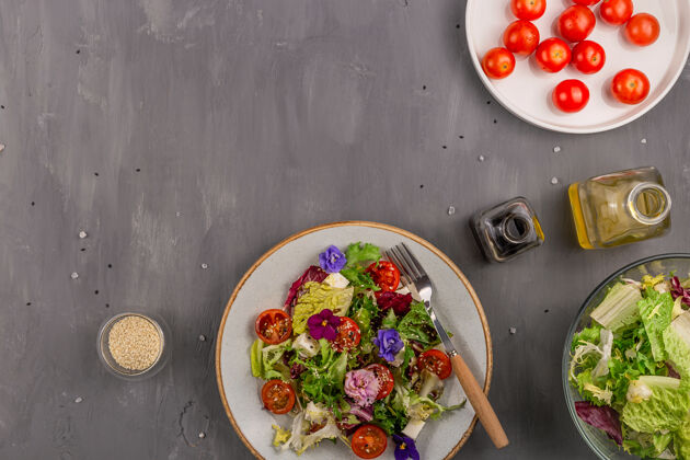 木材一张灰色的桌子上有西红柿 莴苣和奶酪的素食沙拉 上面点缀着可食用的花和配料春季食品概念背景和拷贝空间浪漫叶子素食餐