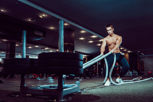 物理健身员在健身房用战绳锻炼肌肉身体健康