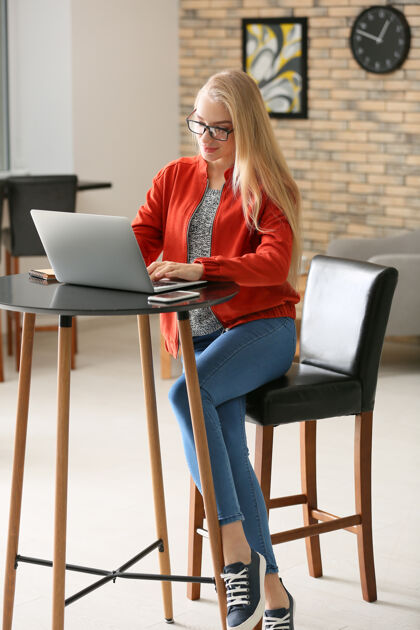 个人电脑美丽的年轻女子在咖啡馆使用笔记本电脑工作服装学习