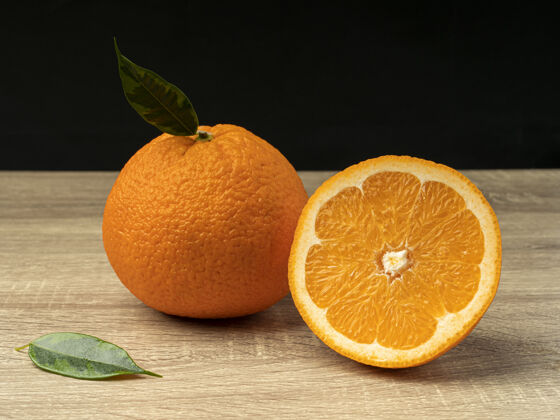 整个橘子片放在灰色的木桌子上营养特写食品
