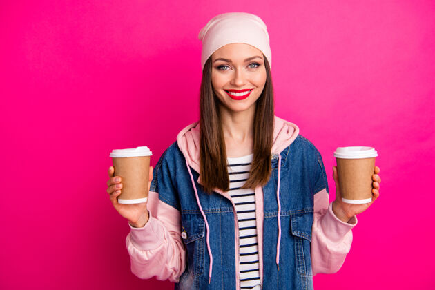 大学近景写真漂亮迷人可爱开朗开朗的女孩手里拿着两个咖啡纸杯给朋友隔离在明亮生动的亮光充满活力的粉红色樱花色时髦外卖茶