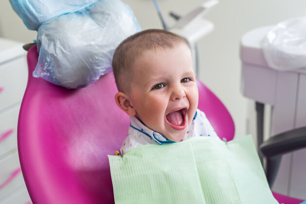 快递小男孩对着牙医的椅子微笑治疗人专家
