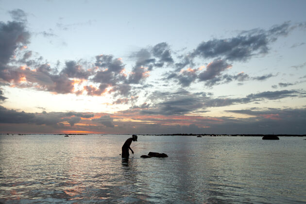 风景日落时分 渔夫在海里捕鱼阳光人黎明