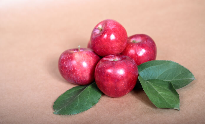 静物绿叶的红苹果躺在浅色的背景上文本空间树叶自然水果