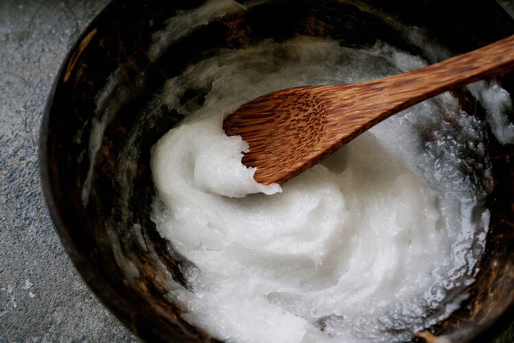 碗有机椰子油放在椰子勺上的椰子碗里可持续性概念闭合油椰子食品