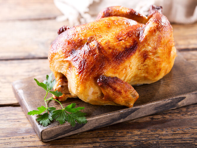 鸡肉整个烤鸡放在木板上晚餐餐脆