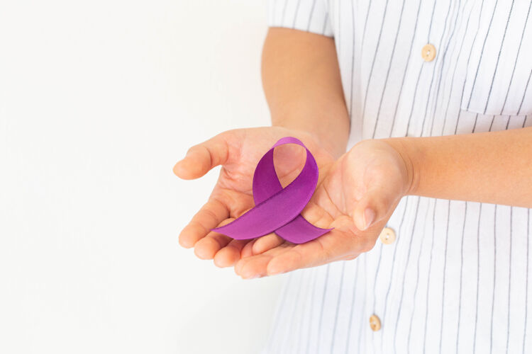 举办手拿紫色或紫色胰腺癌 睾丸癌 癌症幸存者捐赠丝带医疗