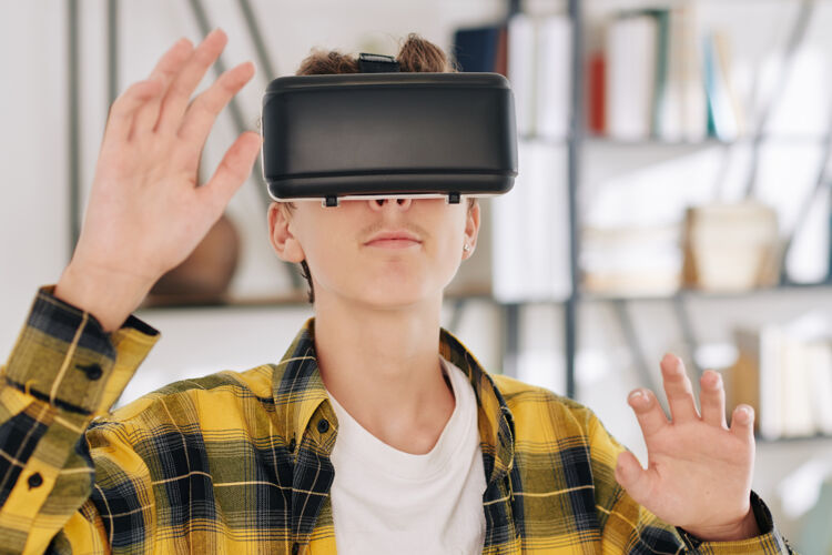 无线技术穿着格子衬衫的少年在家里玩虚拟现实耳机游戏网络空间科技增强现实