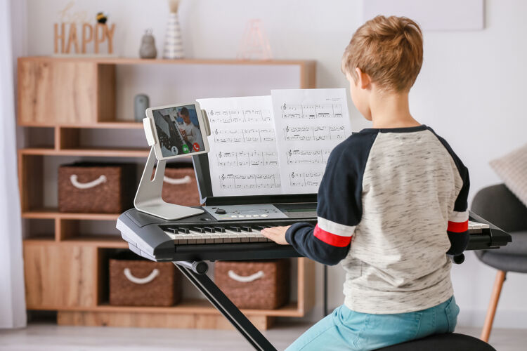 电小男孩在家和他的朋友在线学习音乐学校电子平板电脑