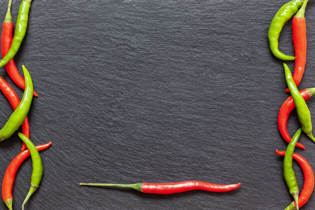 红辣椒在石板板上放上新鲜的辛辣的红 绿辣椒 从上面的深色背景上放上各种五颜六色的辣椒和辣椒顶视图 复制空间辣椒板岩有机