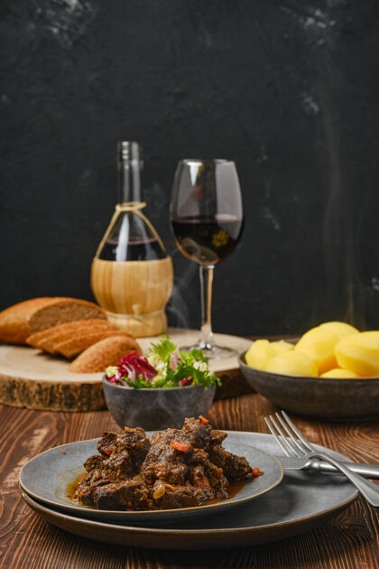 玻璃杯牛肉或鹿配土豆和葡萄酒沙拉牛肉葡萄酒