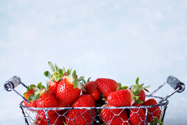 浆果生的红色有机草莓在蓝色的背景上一串市场美味多汁