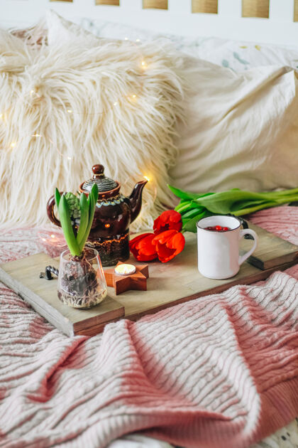 早上好舒适的床上放着茶叶和春花的木制托盘 垂直照片早餐概念高质量的照片柔软惊喜时尚