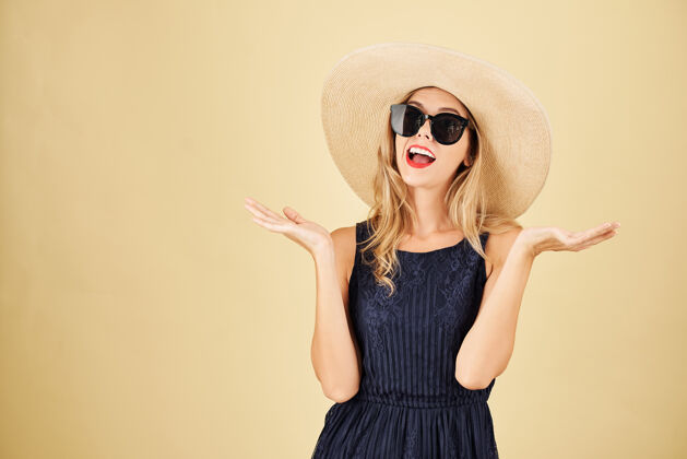 微笑戴着草帽戴着太阳镜的快乐年轻女子的工作室肖像女性太阳镜女人
