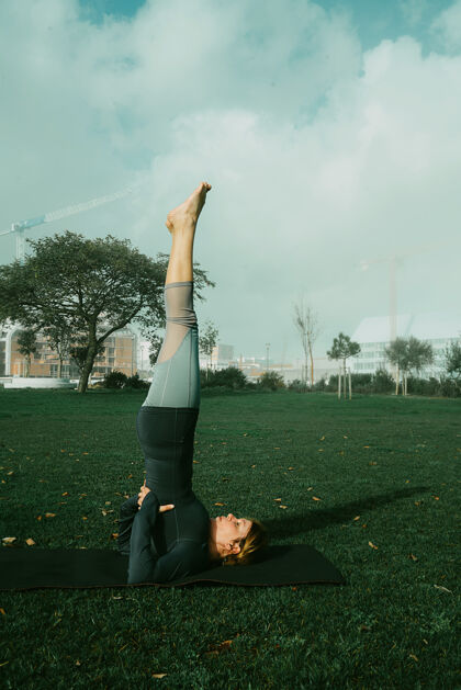 物理在公园里用瑜伽垫做瑜伽 伸展运动 锻炼的年轻女子天生的瑜伽初学者姿势医疗理念瑜伽健康训练