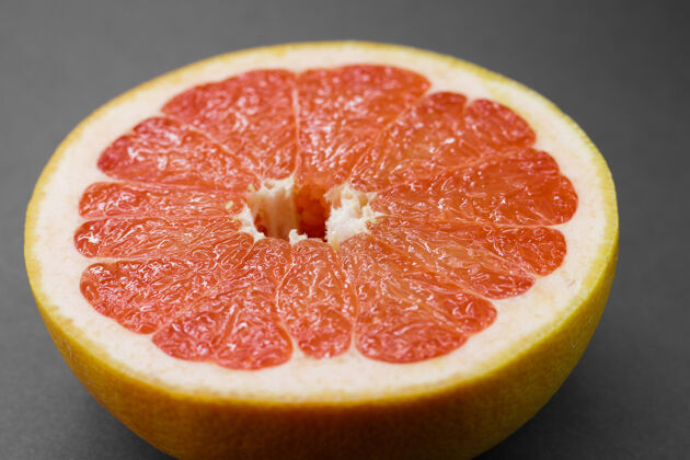 甜味成熟的半个粉红葡萄柚柑橘类水果隔离在灰色背景上灰色背景特写红色