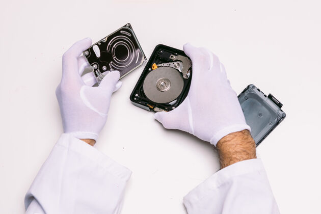 硬盘一个戴着手套的技师的手在修理硬盘技师技术电子