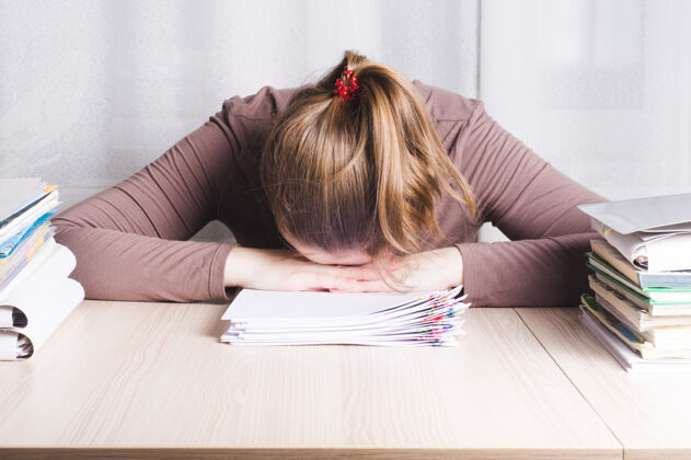 头痛年轻疲惫的女自由职业者在家办公桌上睡觉 工作锻炼疲惫
