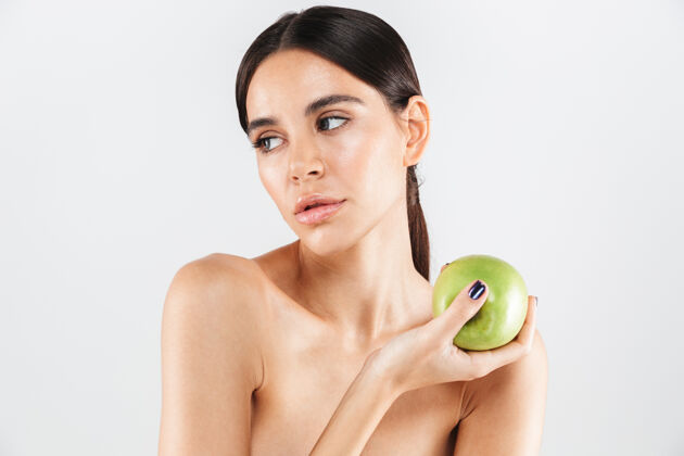 水果美丽的肖像一个迷人的健康的女人孤立地站在白色的墙上 与绿色的苹果摆姿势深色概念皮肤护理