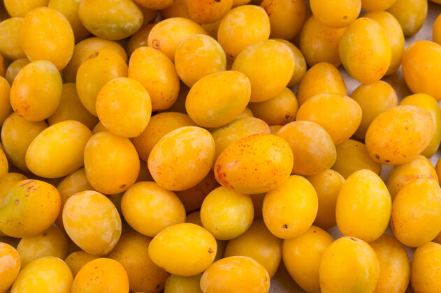 健康黄色的新鲜成熟的李子放在市场的桌子上水果黄色美食