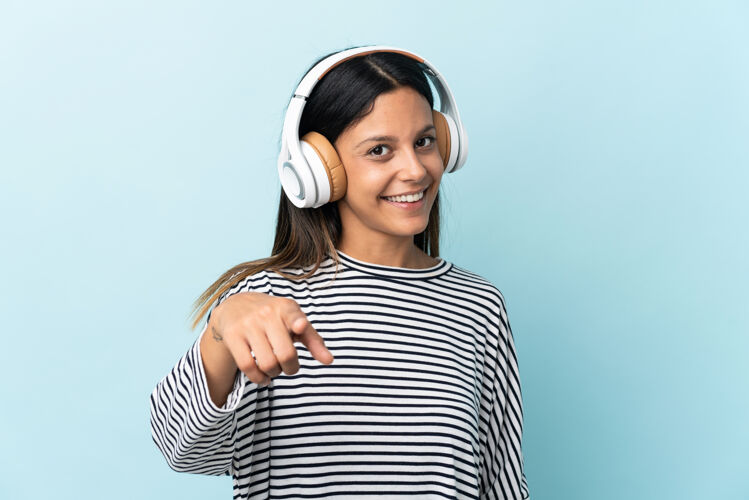 青少年一个被隔离在蓝墙上听音乐的白人女孩女人声音积极