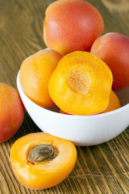 开胃菜刚洗过的杏子放在一个白色的碗里 有些切成两半切有机的对象