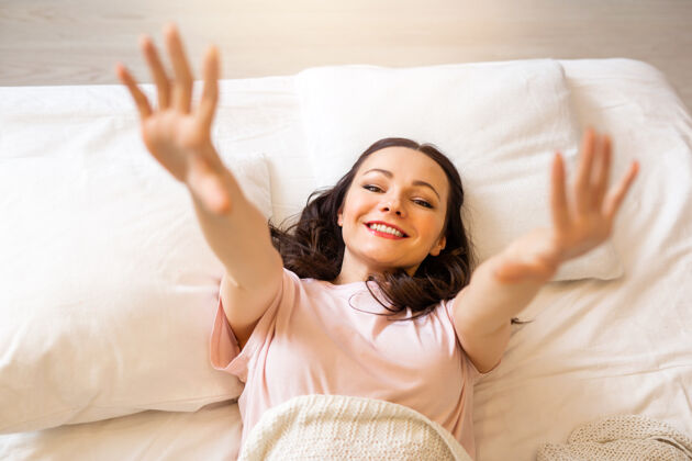 情绪卧室里漂亮的年轻女子躺在枕头上白种人房子肖像