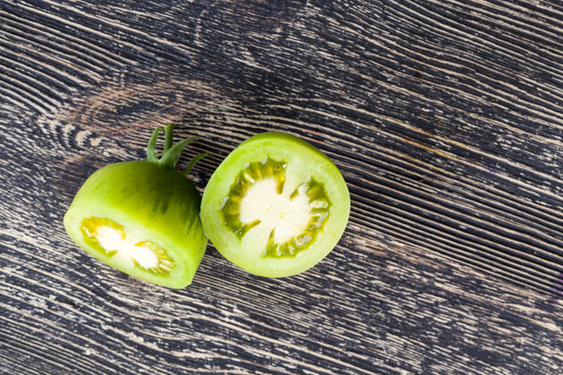 木板在一张黑桌子上切绿色番茄 一个蔬菜的特写谎言烹饪切割