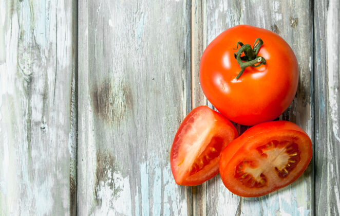 圆形白木桌上放着几片熟番茄营养完美刷新