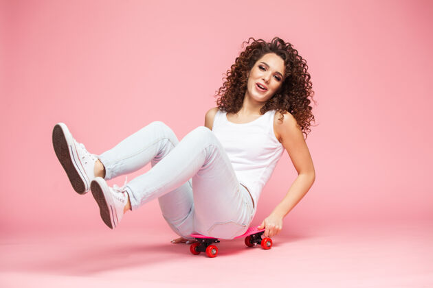 乐趣快乐的年轻女子坐在滑板上 玩得很开心青年年轻女人